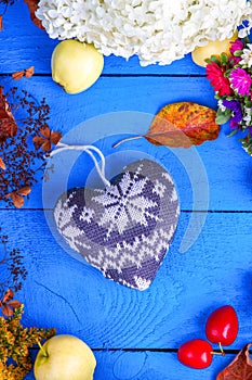 Flowers, plums, apples and heart shape on a table