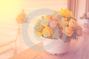 Flowers in a pot on a wooden table with blur background