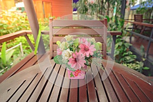 Flowers in a pot on a wooden table with blur background