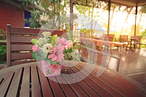 Flowers in a pot on a wooden table with blur background