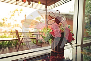 Flowers in a pot on a wooden table with blur background