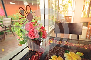 Flowers in a pot on a wooden table with blur background