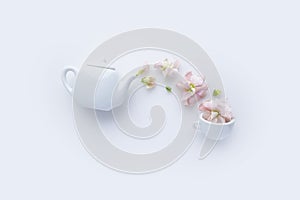 Flowers pouring out from teapot. cutie teapot and cup of flower tea