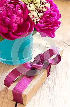 Flowers and present box with ribbon on table,birthday gift.