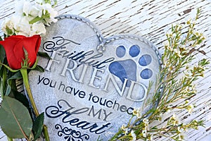 Flowers and a red rose surrounding a heart shaped plaque