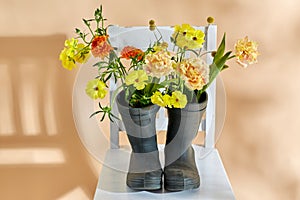 flowers in rubber boots on vintage chair