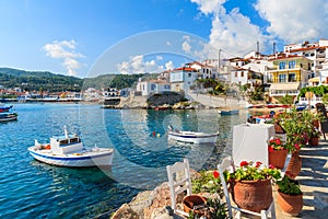 Flowers on shore with fishing boats in Kokkari port, Samos island, Greece