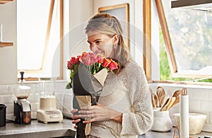 Flowers, smile, and elderly woman smelling rose in a kitchen, surprised by sweet gesture and or secret gift. Happy