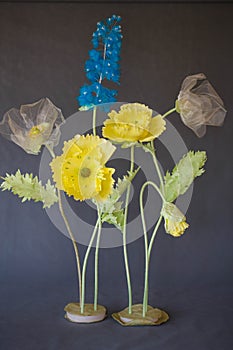 Flowers on a stand on a gray background. Artificial multi-colored bouquet.Flowers on a stand on a gray background. Artificial mult