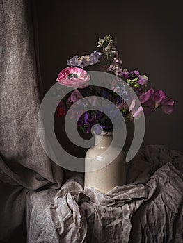 Flowers Still life. Beautiful colorful flowers in vase on moody background. Stylish artistic composition of lathyrus, anemone,