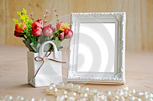 Flowers vase and blank white picture frame.