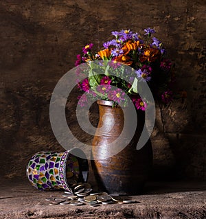 Flowers in vase and pile of old coins
