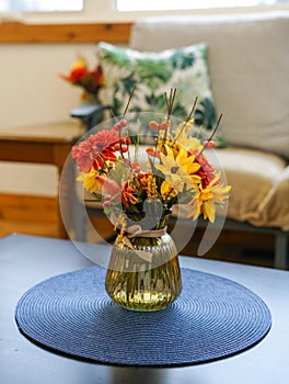 flowers in a vase on a table by a sofa couch
