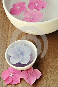 Flowers in a water bowl with a candle for aromatherapy