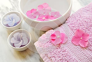 Flowers in a water bowl with a candle and a towel