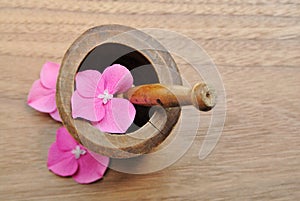 Flowers in wooden pestle for aromatherapy and spa