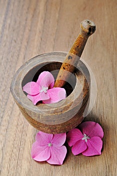 Flowers in a wooden pestle for aromatherapy and spa