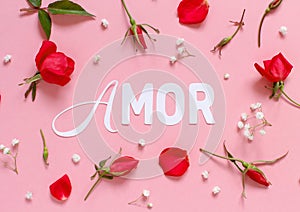 Flowers and word AMOR on a light pink background photo