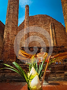Flowers for worshiping monks and the background is a temple built with laterite. This is an ancient art of Ayutthaya
