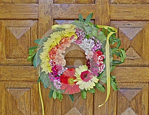 Flowers wreath hanging on wooden door