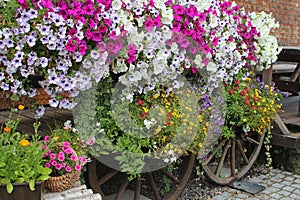 Flowery exterior home decoration with old wooden wheels