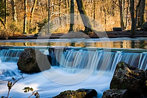Flowing Blue Water under Warm Orange Wiinter Forest