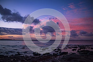 Flowing clouds in sunset sky above ocean