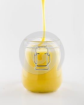 Flowing down honey in glass jar