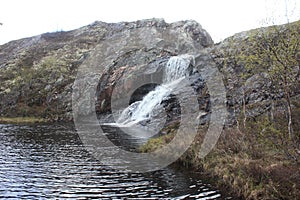 Flowing down from the rocky shore into the lake river.