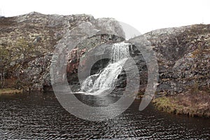 Flowing down from the rocky shore into the lake river.