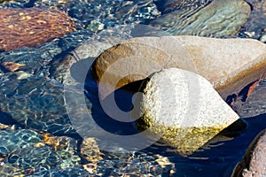 flowing mountain stream with transparent water and stones on bottom
