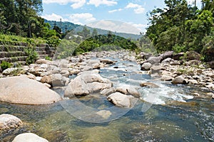 Flowing mountain stream with transparent water and stones