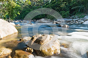 Flowing mountain stream with transparent water and stones