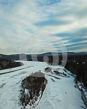 Flowing river at winter. Winter landscape with a River and Winter Forest. aerial view from icy river in winter