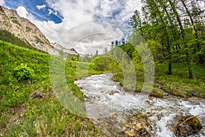 Flowing transparent waters on high altitude alpine stream in idyllic uncontaminated environment in the Italian French Alps. Ultra