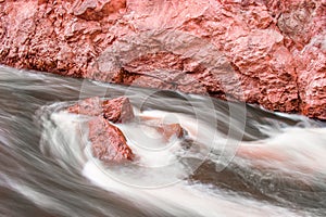 Flowing water around red stones