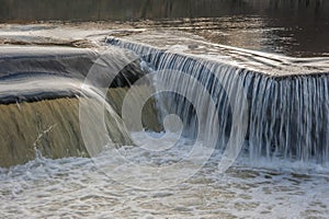 Flowing water cascading over a weir on yorkshire river