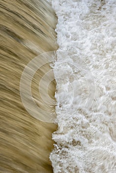 Flowing water cascading over a weir on yorkshire river