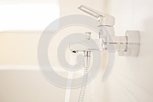 Flowing water of a faucet in a bright bathroom