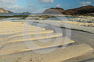 Flowing water at low tide on the Dutch North Sea coast. Beach with a stream running through