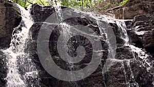 Flowing water in rocky path in natural park. Mountain waterfall stream