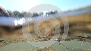 Flowing water of a shallow river on a sunny dayclose-up. Clear cloudless sky