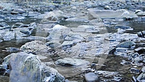 Flowing water of small river between stones