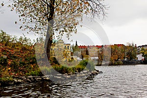Flowing water of Vlatava river against the city landscape of Prague in autumn