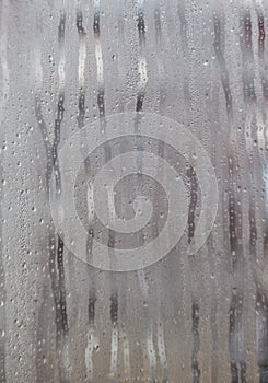 Flows on the misted window-glass. Close-up. Background