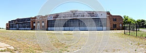 Floyd Bennett Field, grass covered lawn, abandoned hangar with Art Deco elements in the background, New York, NY, USA