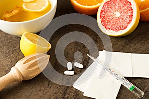 Flu killers - vitamins from citrus, tea with ginger, pills, thermometer and tissues