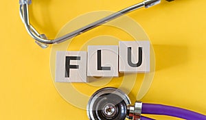 FLU the word is written on wooden cubes and sthetoscope. Medical concept