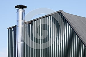 Flue chimney fixed to building exterior wall stainless steel from exhaust boiler plant room