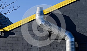 Flue chimney fixed to building exterior wall stainless steel from exhaust boiler plant room